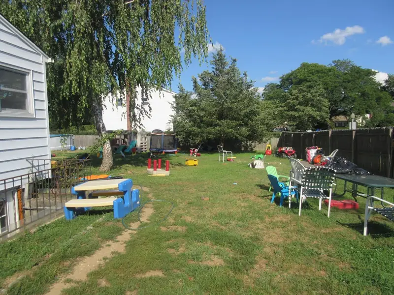 Backyard scattered with toys and play equipment, Commack, NY